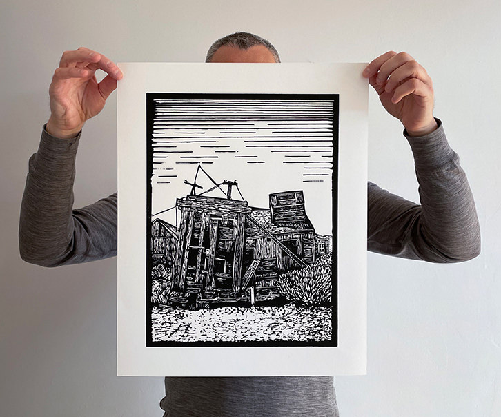Kevin Allan holding medium giclee print of ghost town sawmill